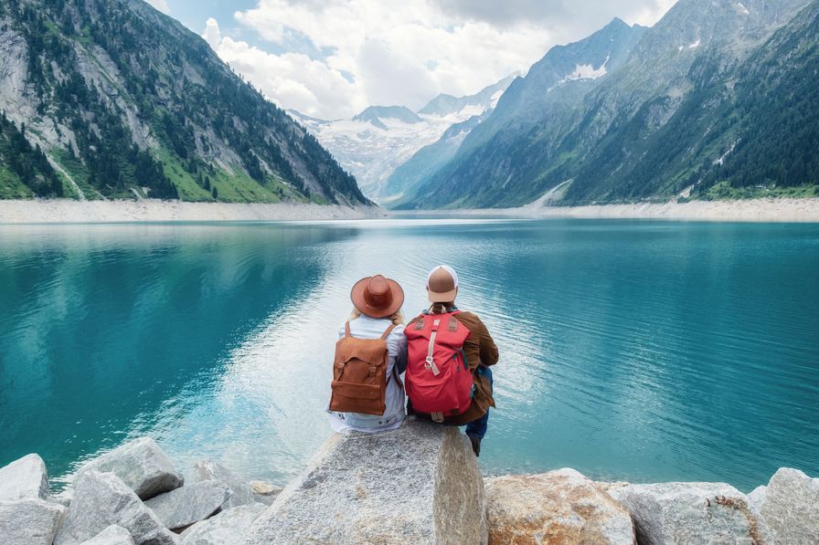 Two adventurers by mountain lake using XeSIM to stay connected while exploring remote, scenic destinations.