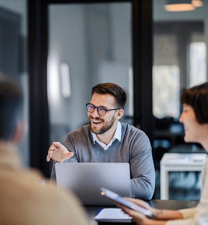 Three people in a meeting room, symbolizing the collaboration and teamwork that led to the creation of XeSIM.